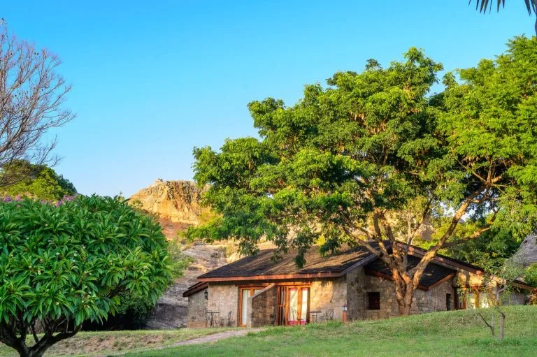 Bungalow en pierre au couchant dans un parc arboré, région de l'Isalo